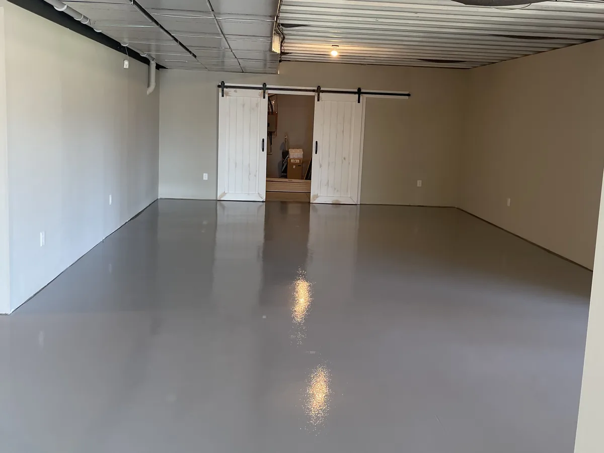 Finished basement with a solid color epoxy floor