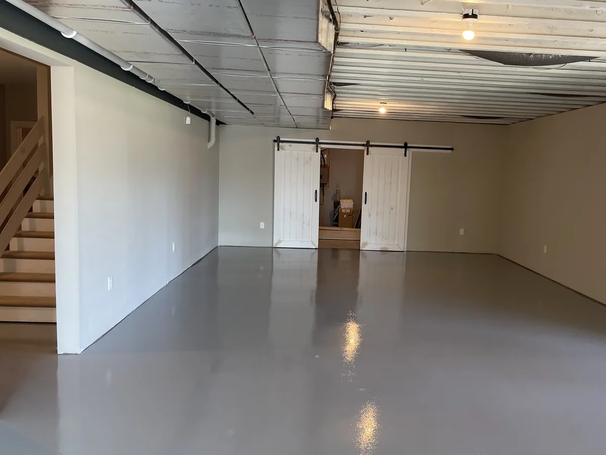 Finished basement with a solid color epoxy floor