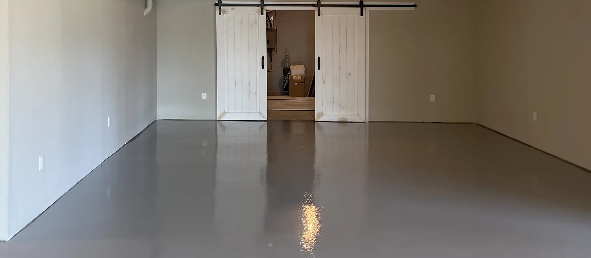 Grey epoxy floor lying dead flat wall to wall in a finished basement