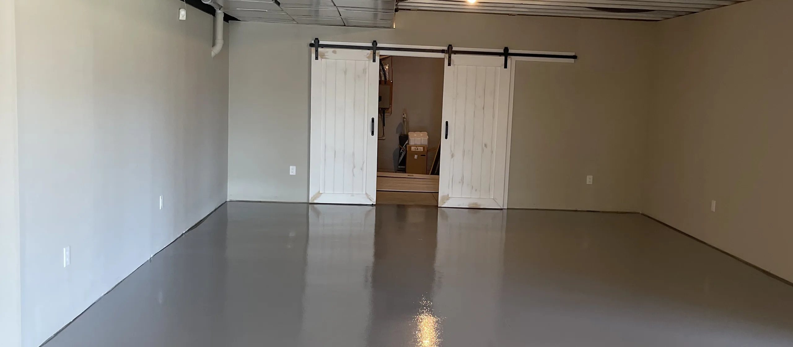 Finished basement floor coated in solid color epoxy by Liberty Epoxy
