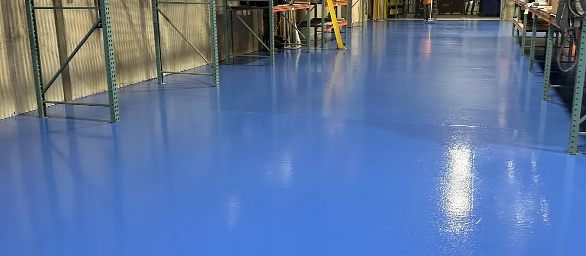 Blue solid color epoxy floor between warehouse racking