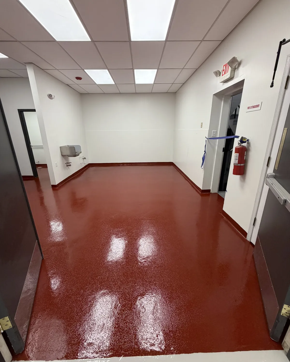 Tile red epoxy floor with a coved base in a commercial utility room