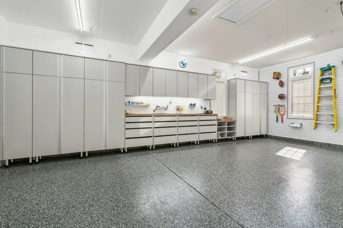 Flake epoxy garage floor with white custom cabinets