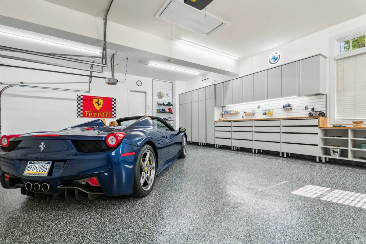 Sports car parked on a finished flake epoxy garage floor with custom cabinets