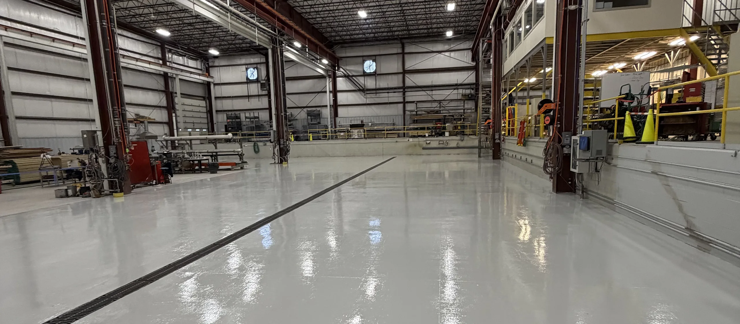 Solid color epoxy floor down the length of an industrial plant bay