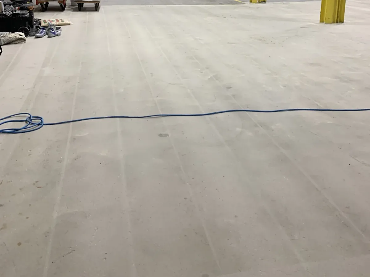 Same fabrication bay floor before coating, bare worn concrete