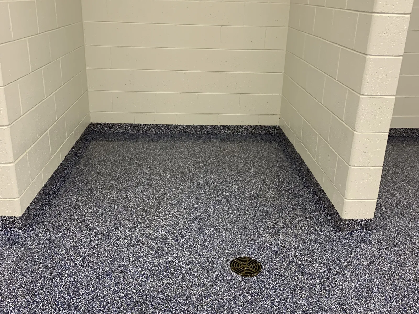 Blue quartz broadcast epoxy floor in a commercial washroom