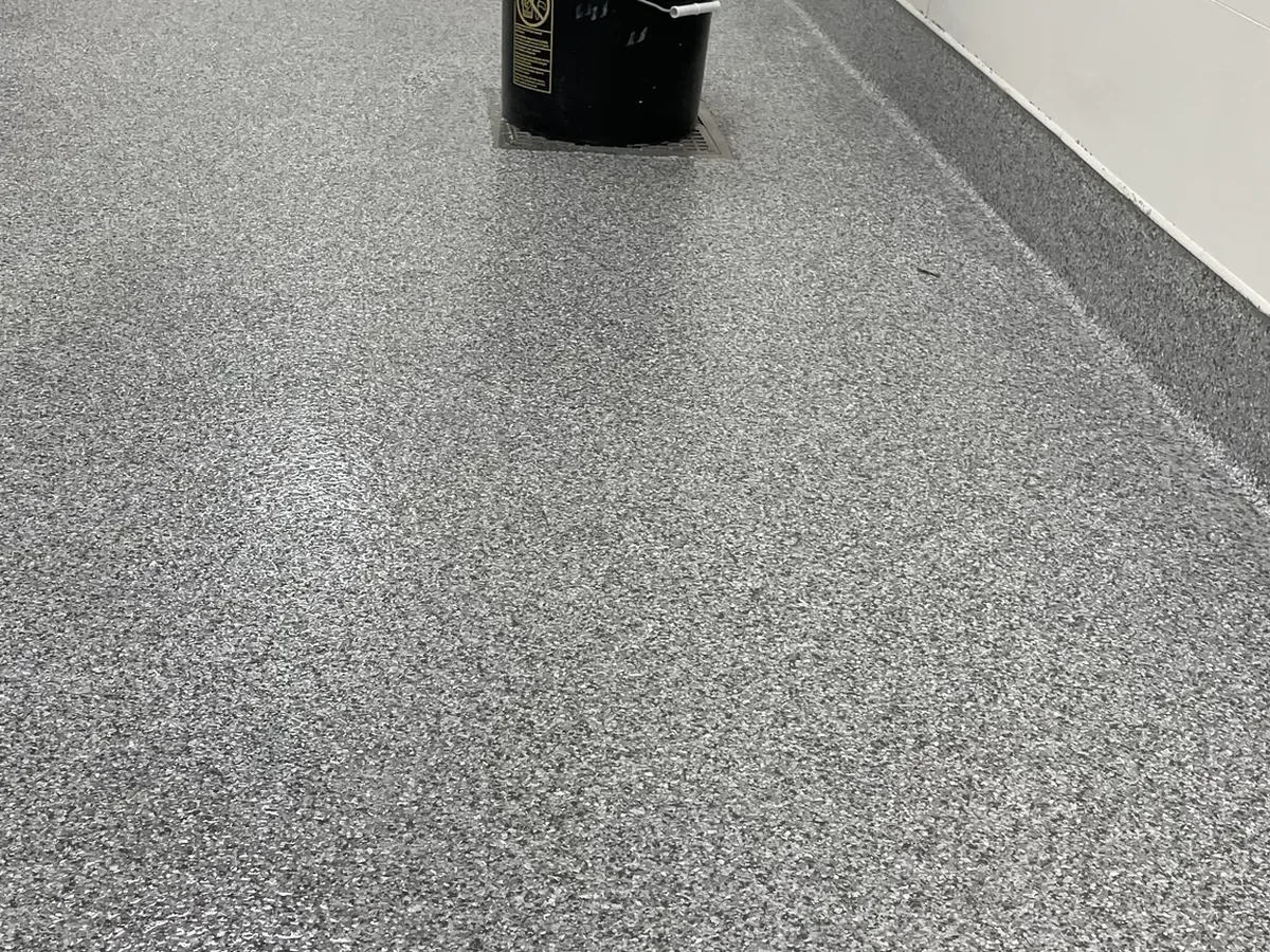 Quartz broadcast epoxy floor running down a facility corridor