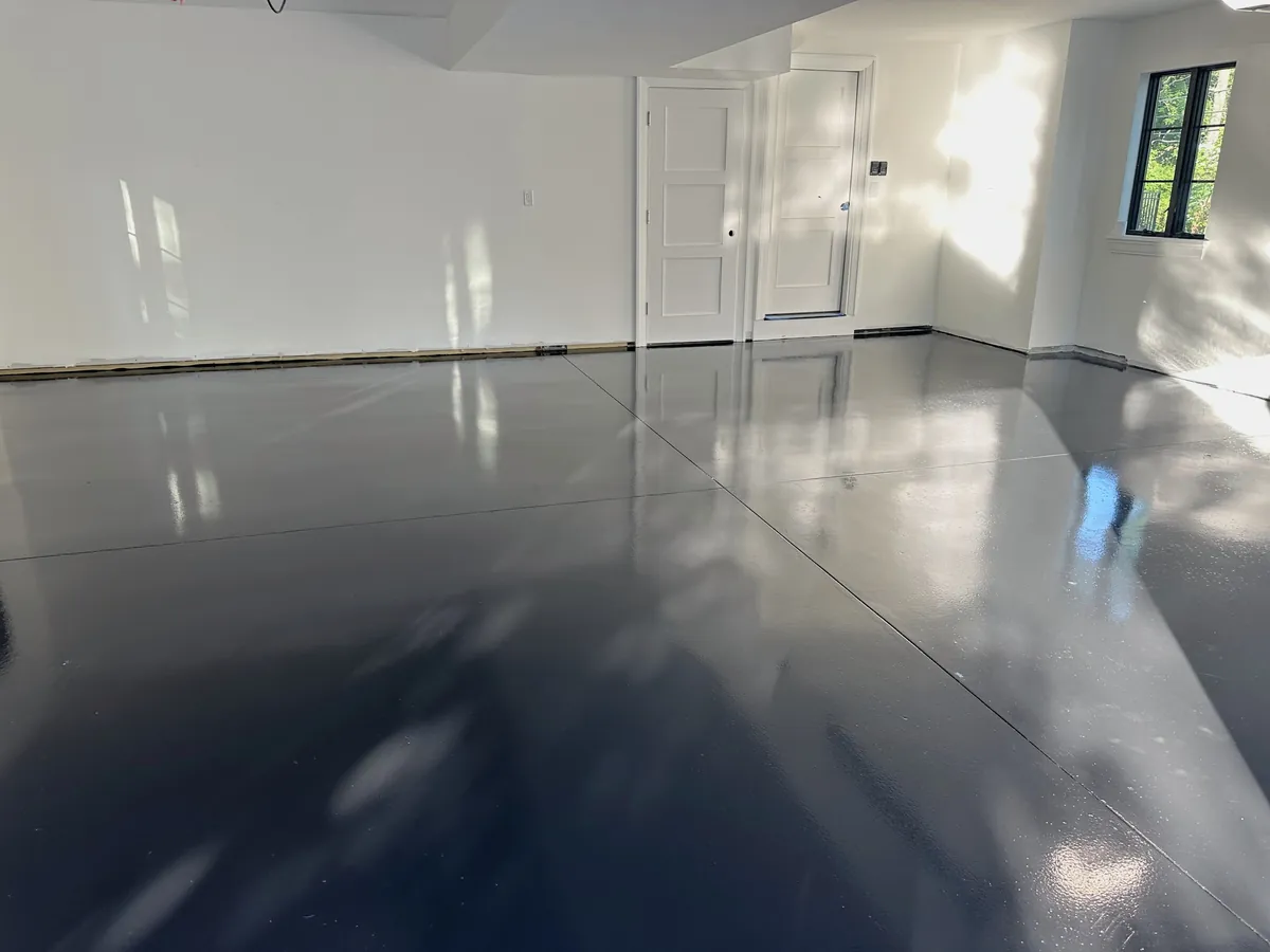 Dark solid color epoxy floor with a high gloss in a bright open room