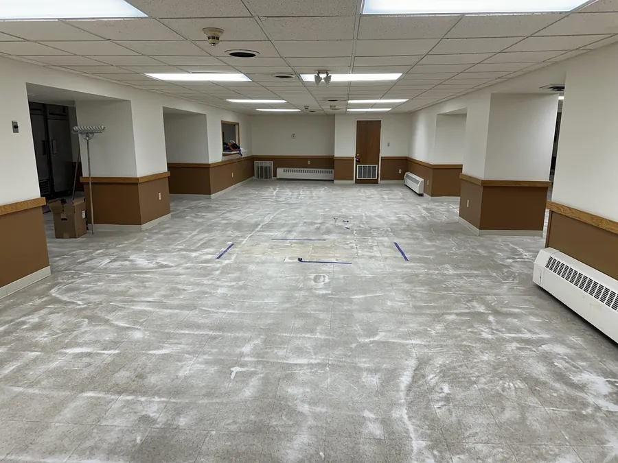 Same lower-level floor before coating, bare concrete