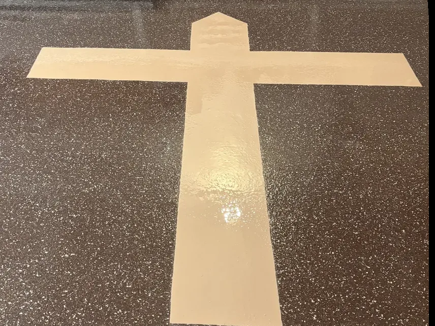 Custom cross inlay set into an epoxy floor