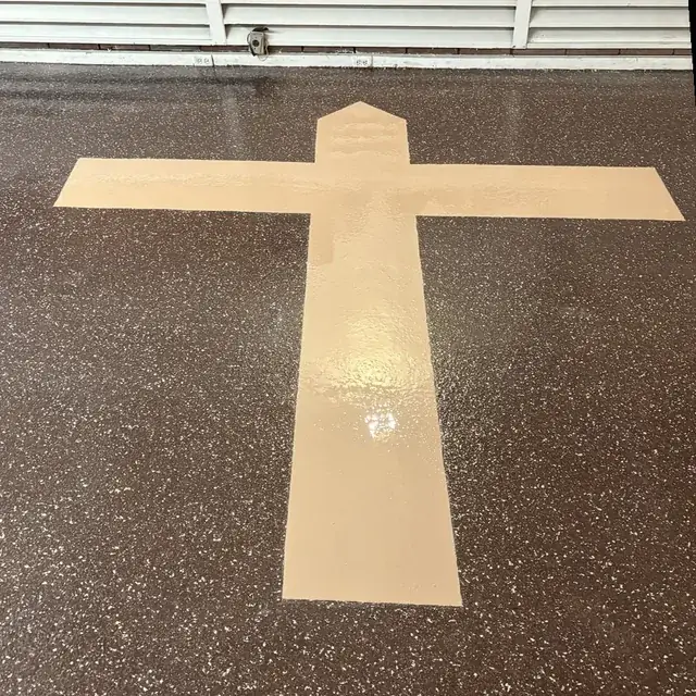 Epoxy floor with custom cross inlay in a church