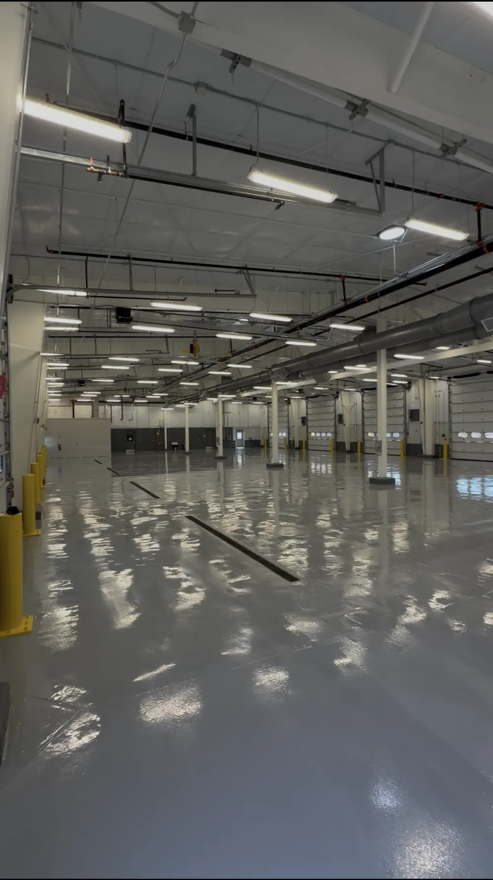 Solid color epoxy floor running the length of an industrial vehicle bay