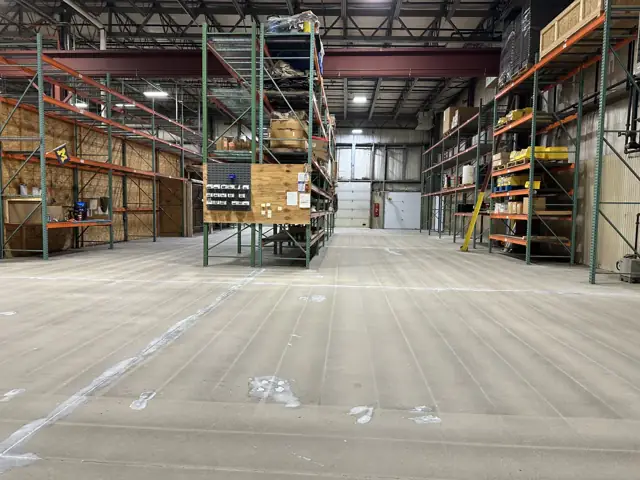 Same warehouse floor before coating, worn bare concrete